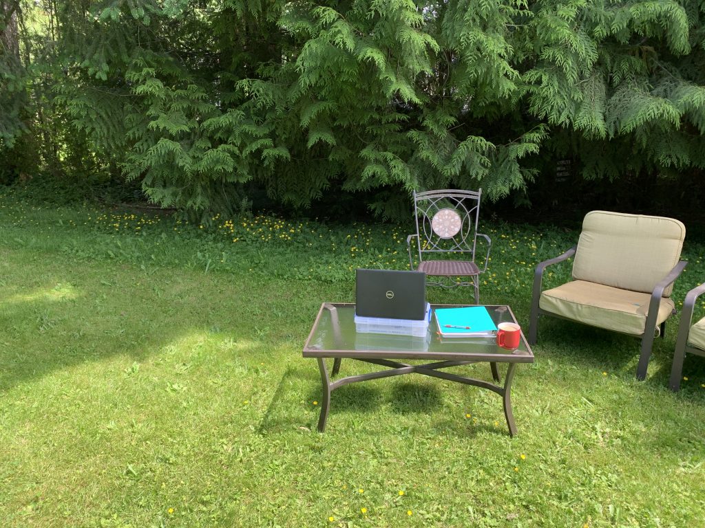 A laptop and school books set up in the backyard