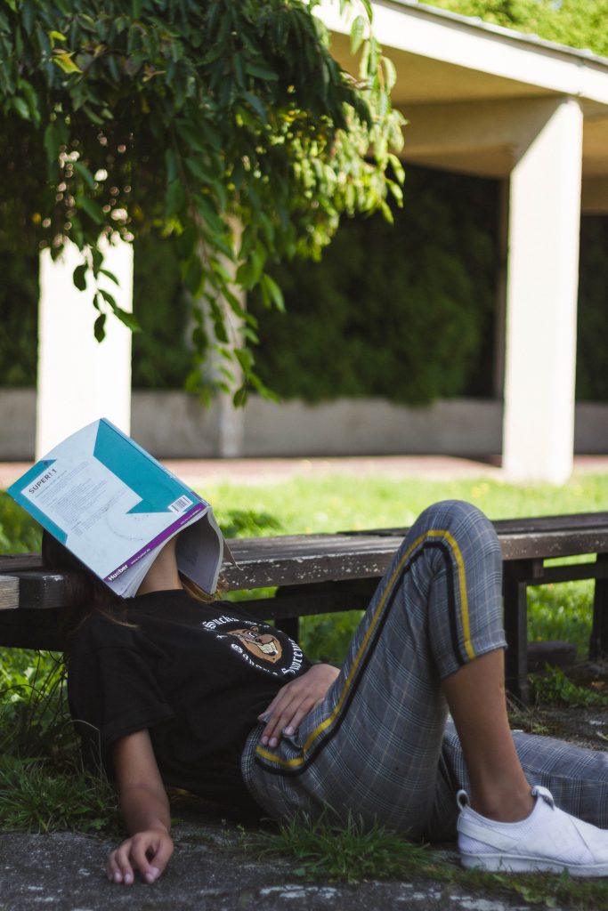 A student sleeping with a book on their head