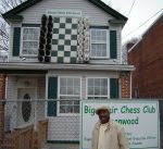 Picture of the chess house with Eugene standing in front of it. 